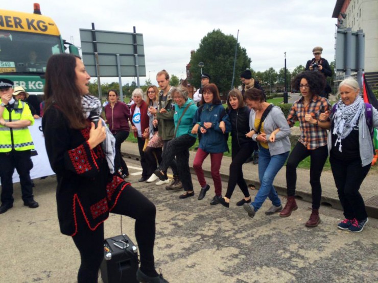 A line of people dancing in front of a truck